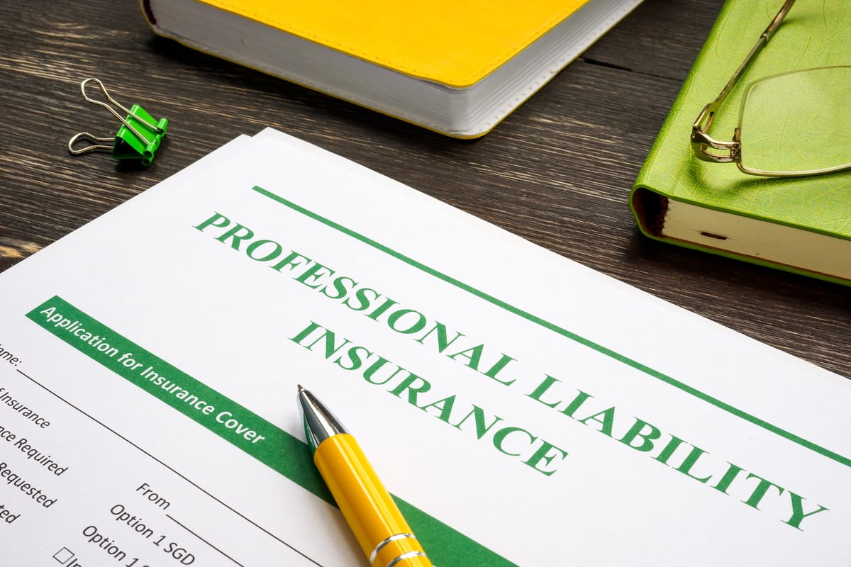 Professional liability insurance form with a pen ready for signing