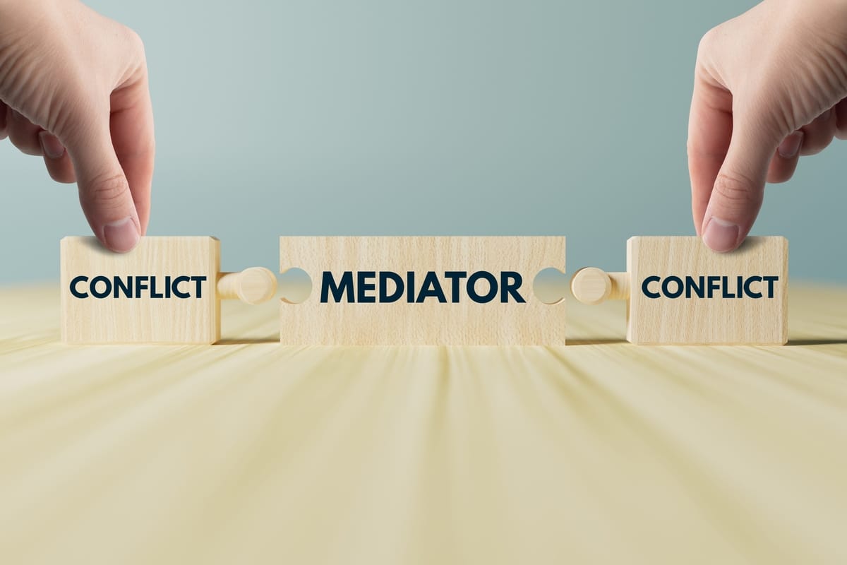 Wooden blocks spelling conflict and mediator, representing mediation and arbitration