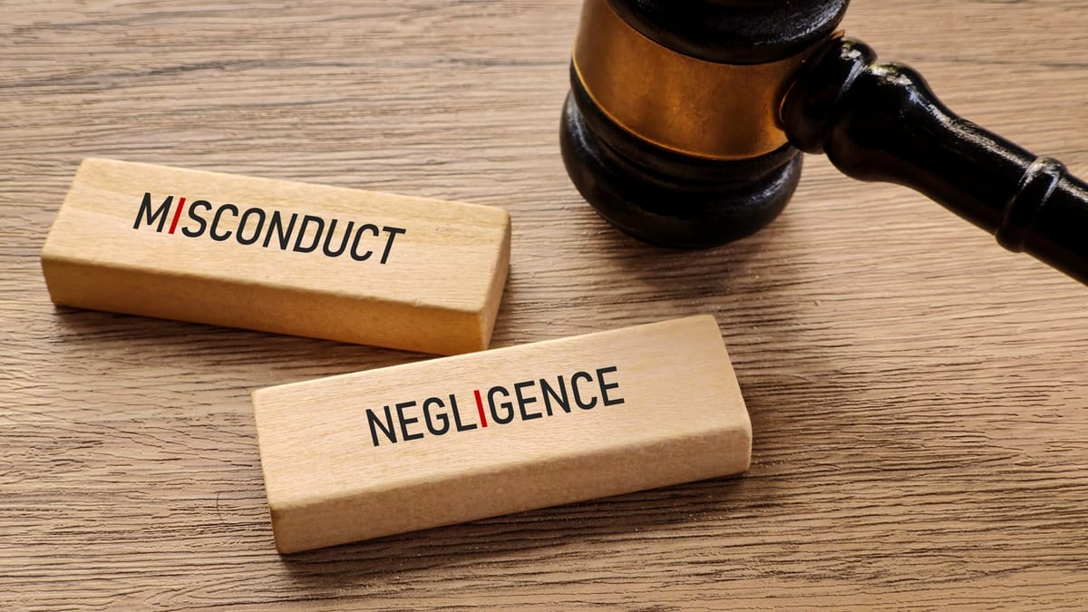 Gavel on a wooden table beside misconduct and negligence paperwork