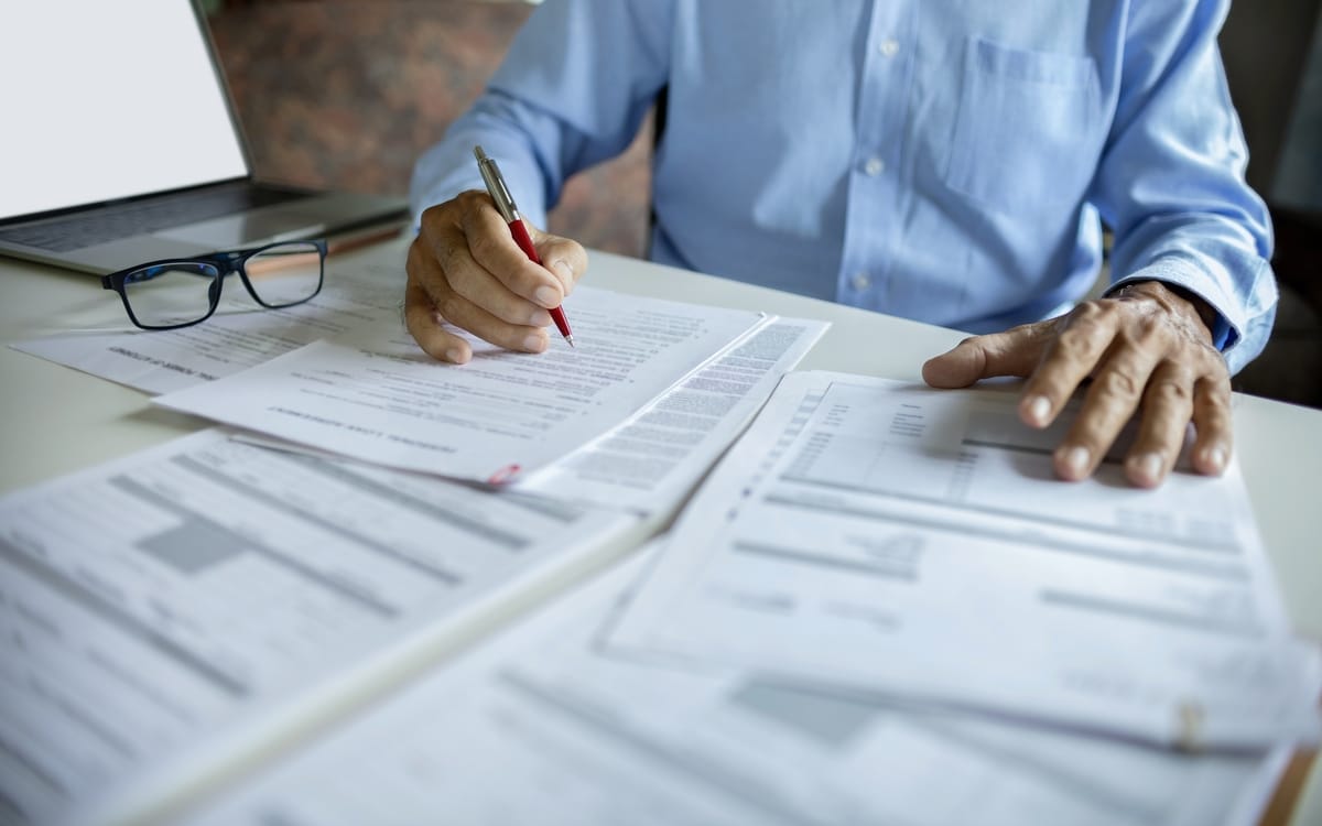 Attorney reviewing an insurance policy document at a desk