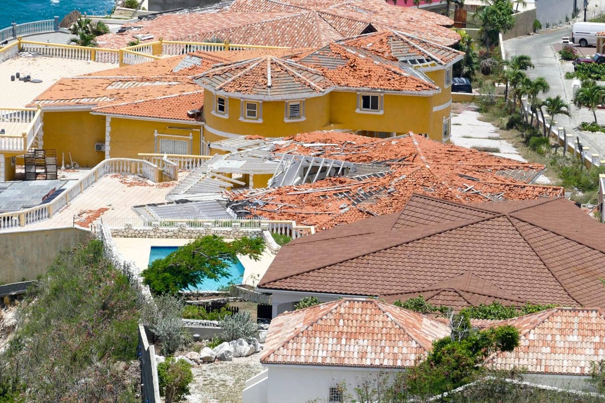 Aerial view of homes with roof damage after a hurricane